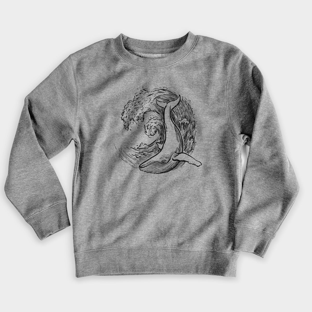 Nickel grey youth crewneck sweatshirt laid flat, printed with a black ink illustration of a humpback whale swimming inside a curling ocean wave.