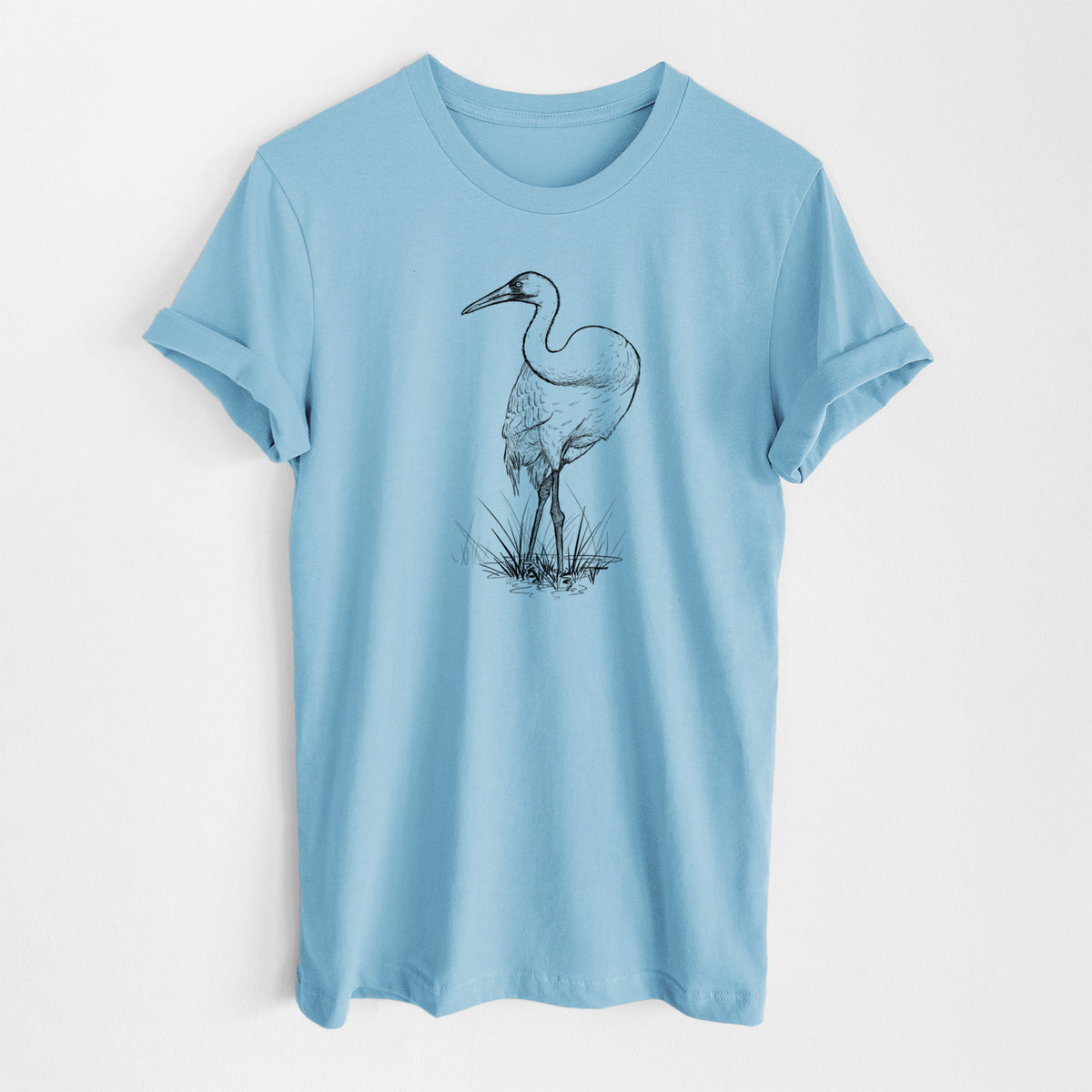 Ocean blue lightweight cotton t-shirt laid flat, printed with a detailed black ink illustration of a whooping crane standing in grass.