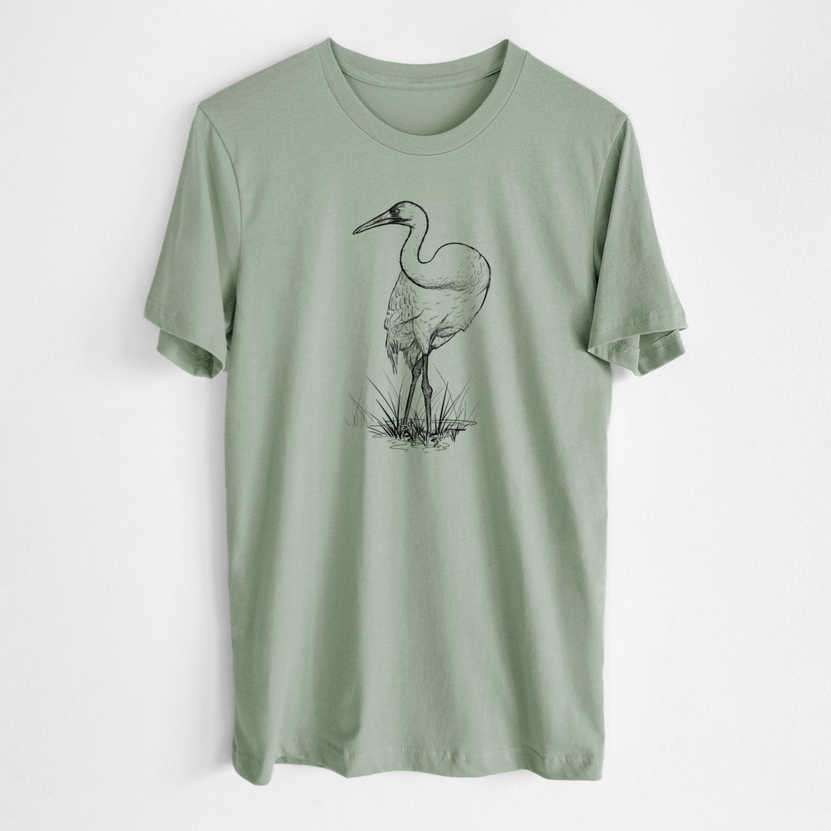 Sage green lightweight cotton t-shirt laid flat, printed with a detailed black ink illustration of a whooping crane standing in grass.
