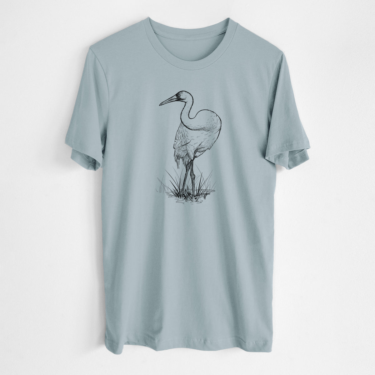 Vintage denim lightweight cotton t-shirt laid flat, printed with a detailed black ink illustration of a whooping crane standing in grass.