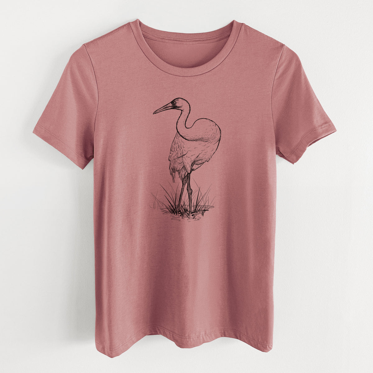 Mauve pink women's relaxed fit cotton t-shirt laid flat, printed with a detailed black ink illustration of a whooping crane standing in grass.