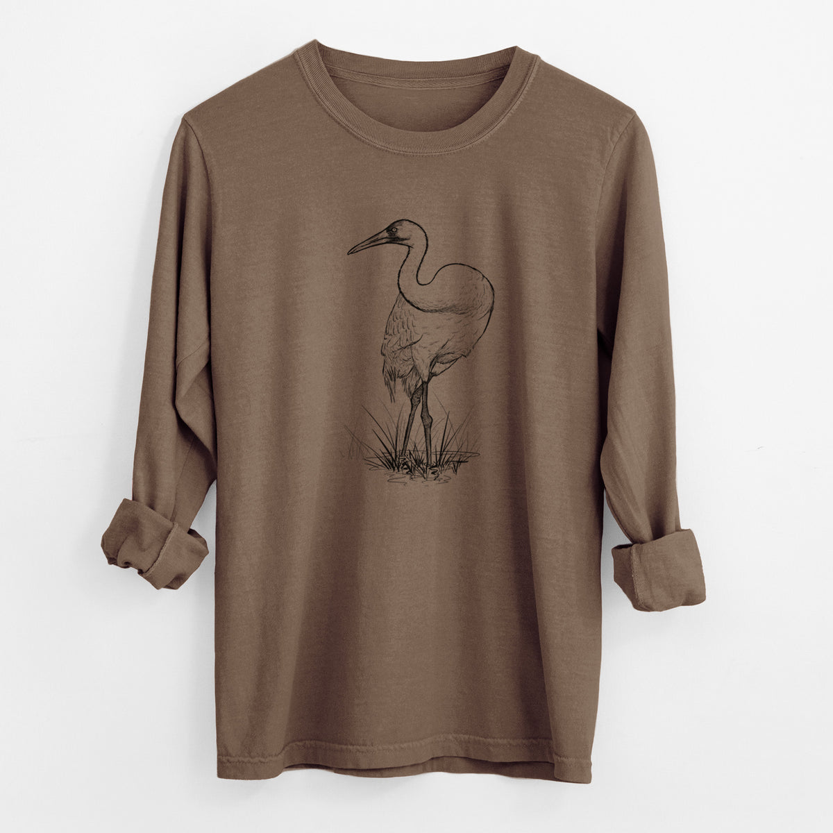 Espresso brown Comfort Colors long sleeve shirt laid flat with the cuffs rolled, printed with a detailed black ink illustration of a whooping crane standing in grass.
