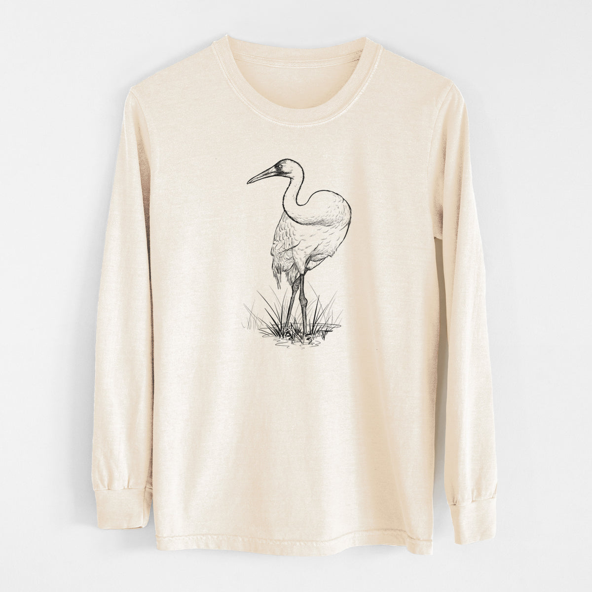 Ivory Comfort Colors long sleeve shirt laid flat, printed with a detailed black ink illustration of a whooping crane standing in grass.