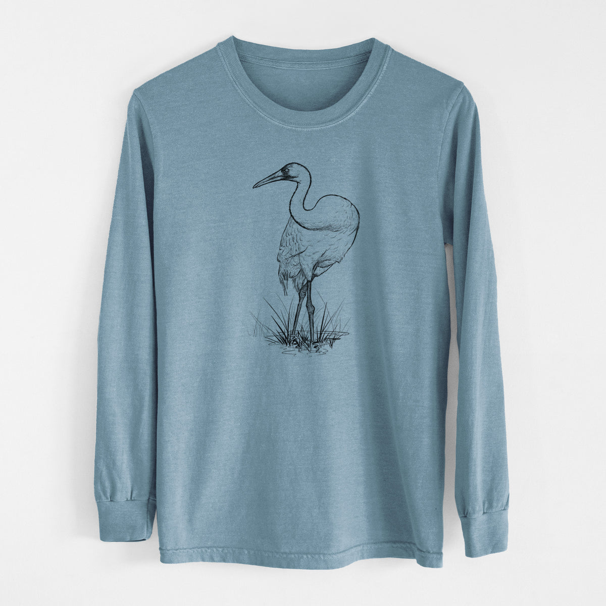 Steel blue Comfort Colors long sleeve shirt laid flat, printed with a detailed black ink illustration of a whooping crane standing in grass.