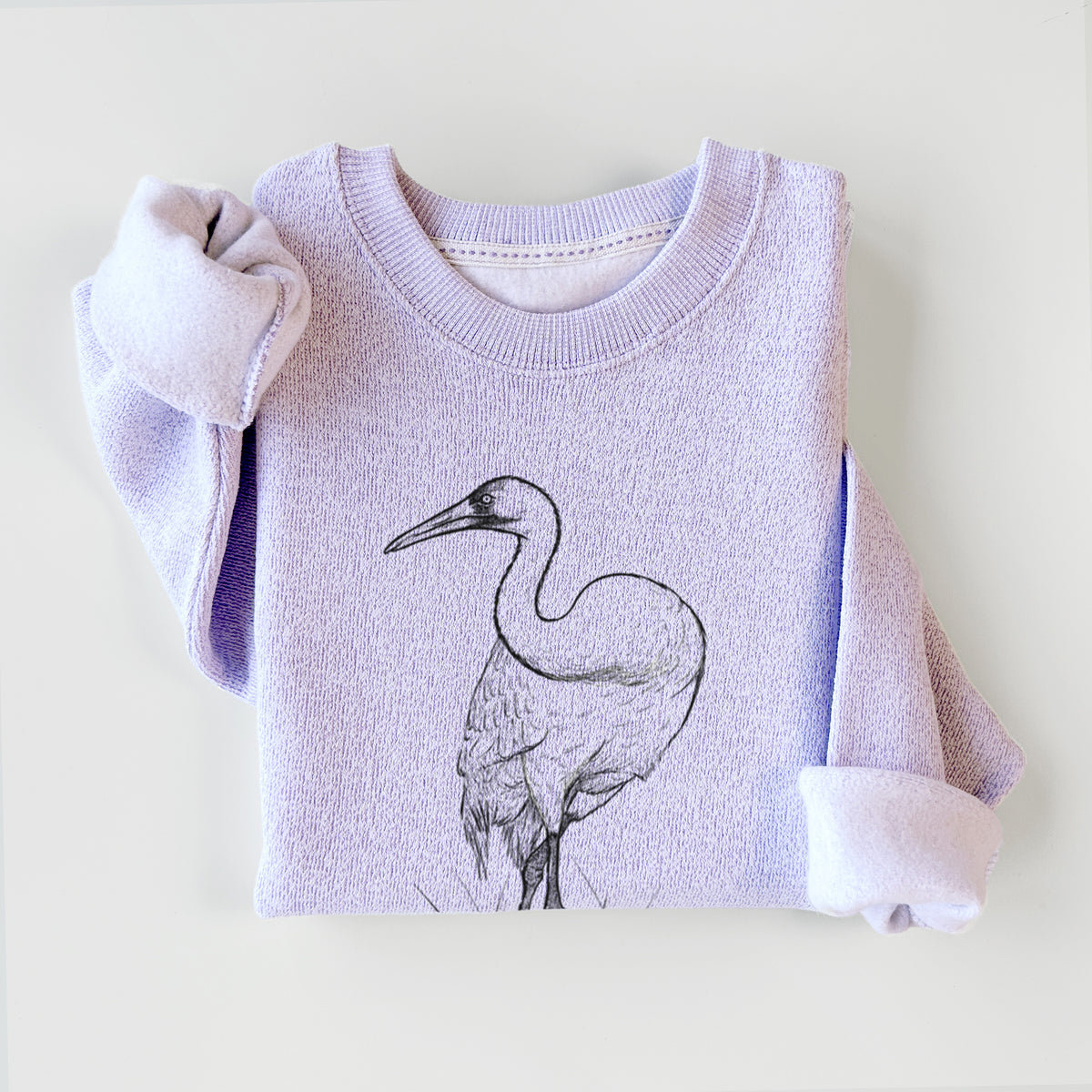 Ice purple knit sweatshirt printed with a detailed black ink illustration of a whooping crane standing in grass, styled flat.