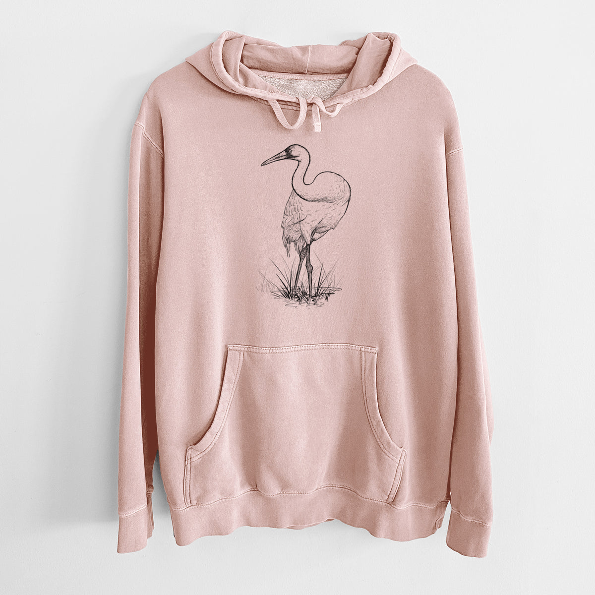 Dusty pink pigment dyed hoodie laid flat, printed with a detailed black ink illustration of a whooping crane standing in grass.