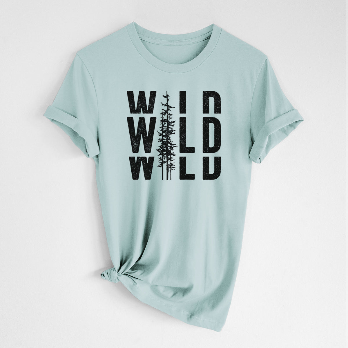 Dusty blue lightweight cotton t-shirt laid flat with the sleeves rolled, printed with bold black text reading WILD stacked three times, with a tall pine tree forming the letter I.
