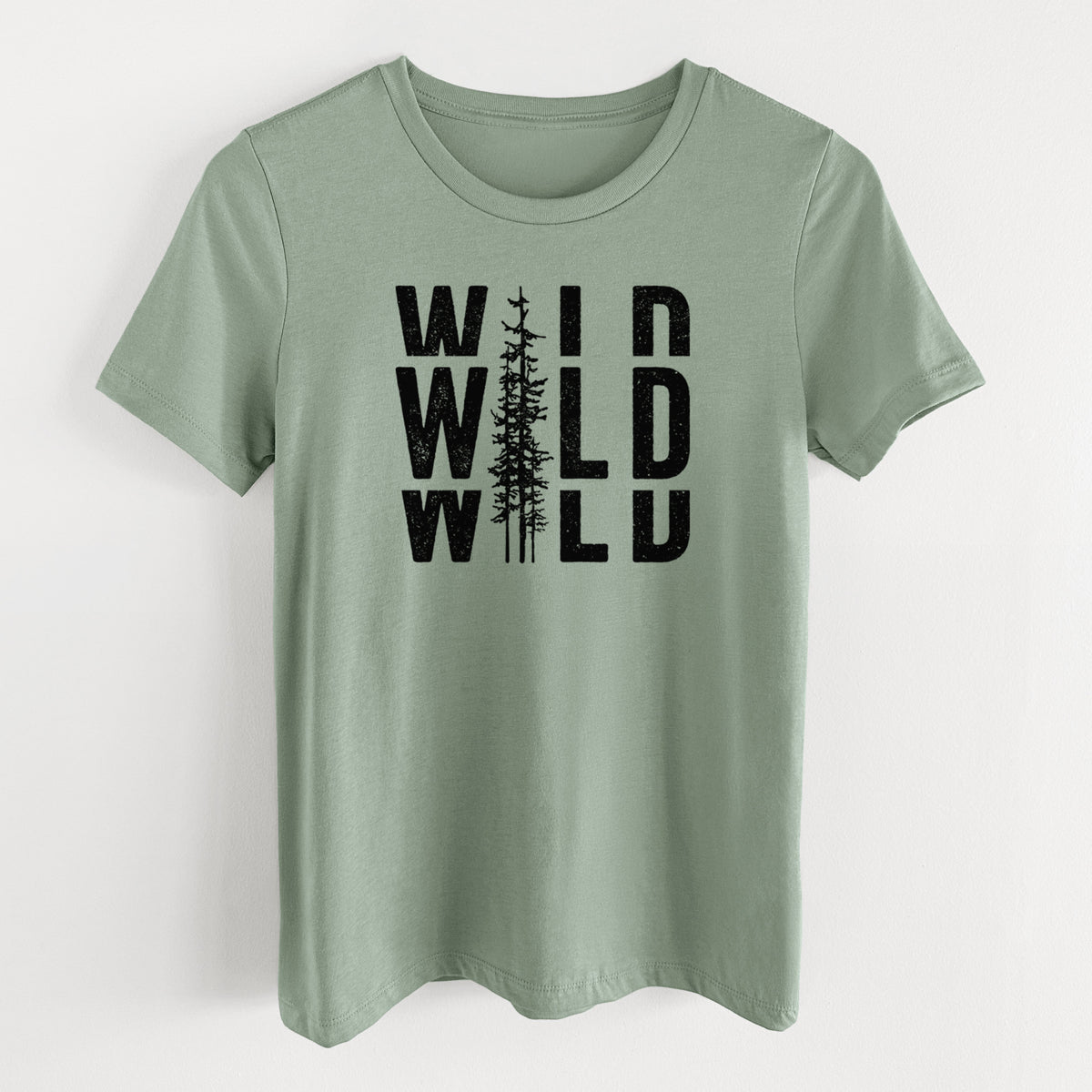 Sage green women's relaxed fit cotton t-shirt laid flat, printed with bold black text reading WILD stacked three times, with a tall pine tree forming the letter I.