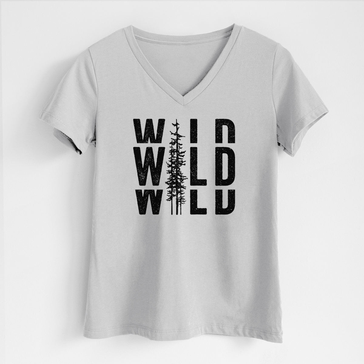 Lunar grey women's relaxed fit cotton V-neck t-shirt laid flat, printed with bold black text reading WILD stacked three times, with a tall pine tree forming the letter I.