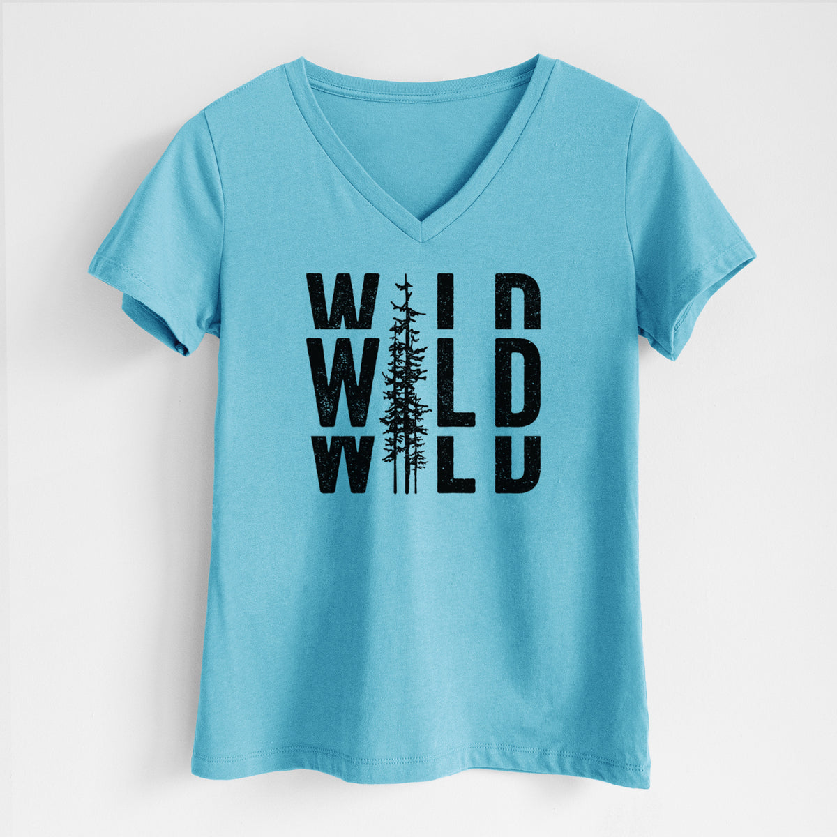 Turquoise women's relaxed fit cotton V-neck t-shirt laid flat, printed with bold black text reading WILD stacked three times, with a tall pine tree forming the letter I.