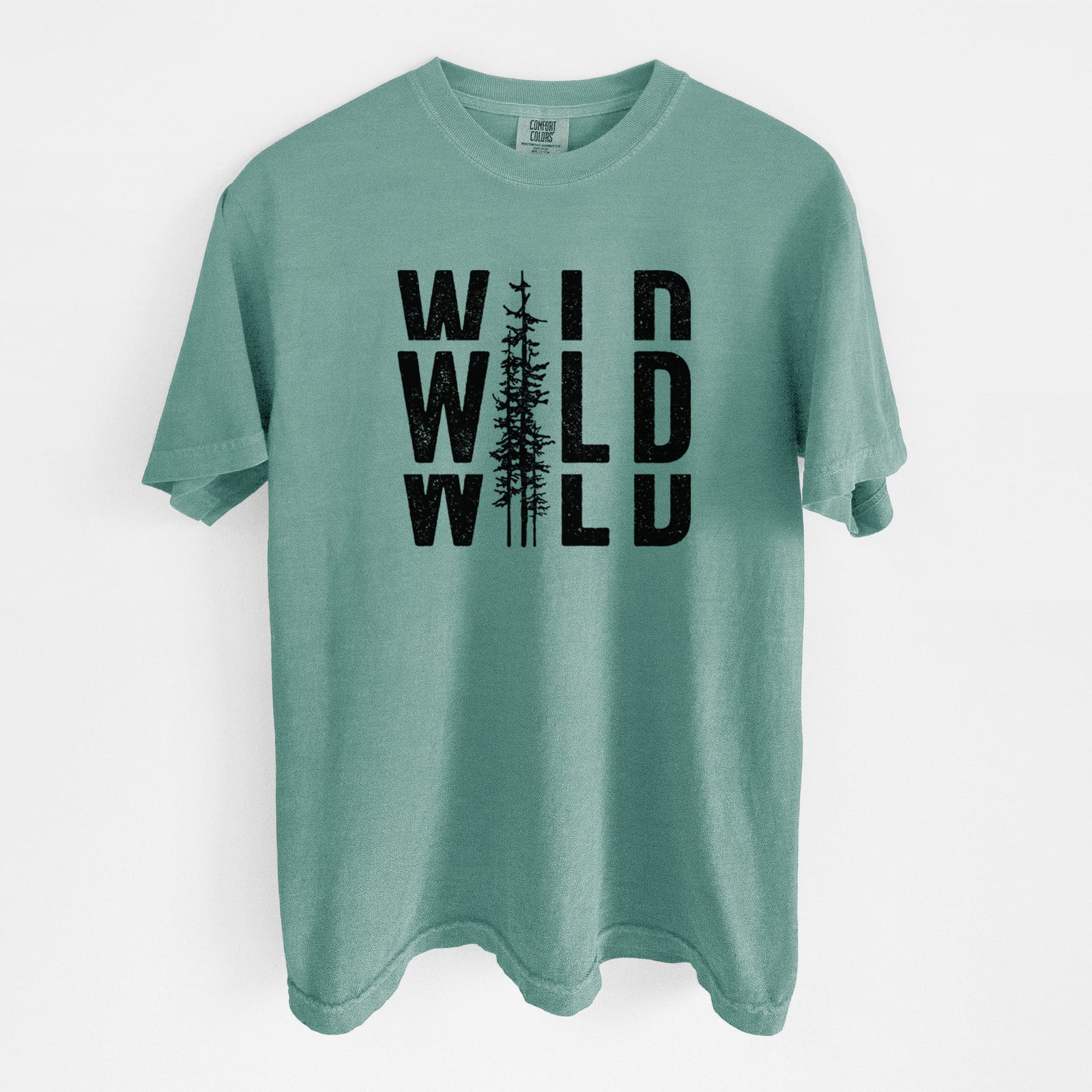 Blue jean Comfort Colors t-shirt laid flat, printed with bold black text reading WILD stacked three times, with a tall pine tree forming the letter I.