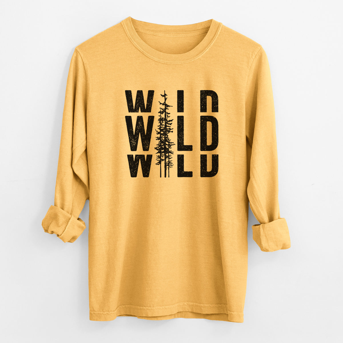 Golden wheat yellow Comfort Colors long sleeve shirt laid flat with the cuffs rolled, printed with bold black text reading WILD stacked three times, with a tall pine tree forming the letter I.