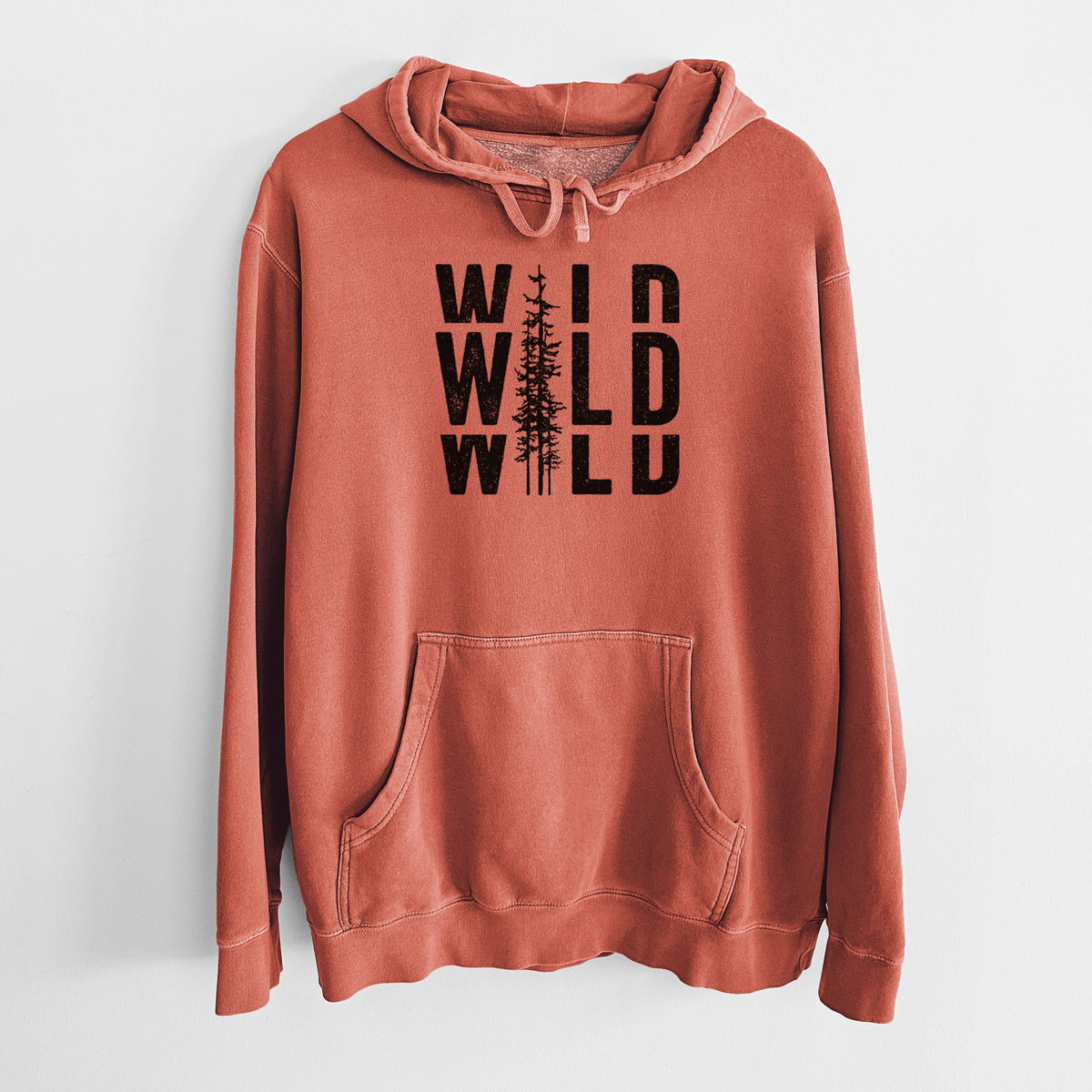 Amber orange pigment dyed hoodie laid flat, printed with bold black text reading WILD stacked three times, with a tall pine tree forming the letter I.