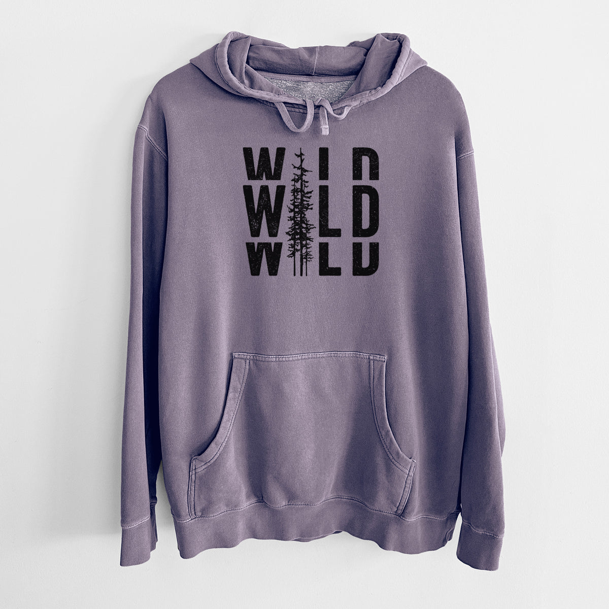 Plum purple pigment dyed hoodie laid flat, printed with bold black text reading WILD stacked three times, with a tall pine tree forming the letter I.