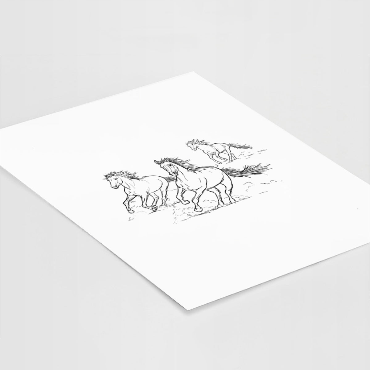 Art print of a black ink illustration of three wild horses galloping, lying at an angle on a white surface.