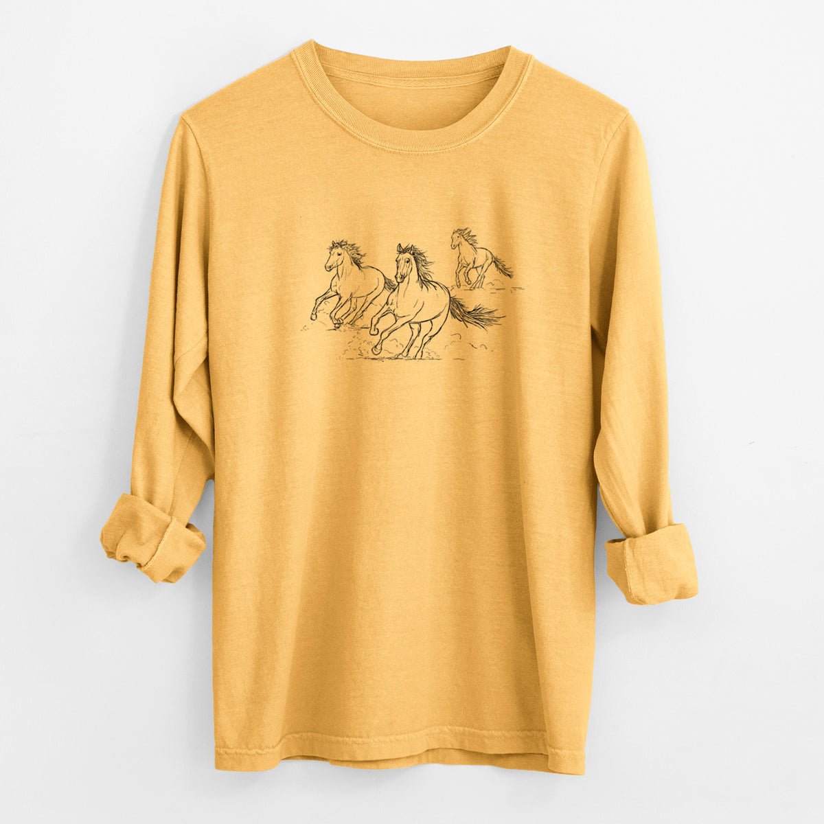 Golden wheat yellow Comfort Colors long sleeve shirt laid flat with the cuffs rolled, printed with a black ink illustration of three wild horses galloping.