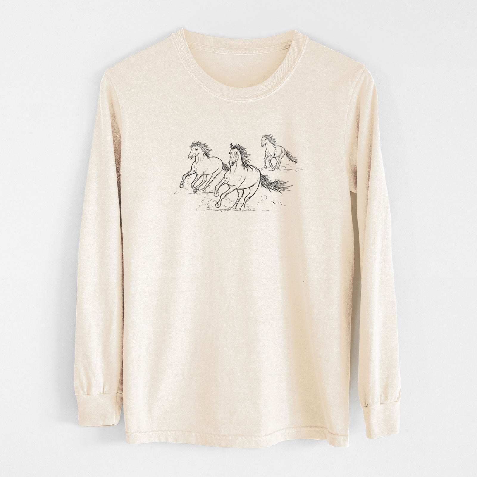 Ivory Comfort Colors long sleeve shirt laid flat, printed with a black ink illustration of three wild horses galloping.