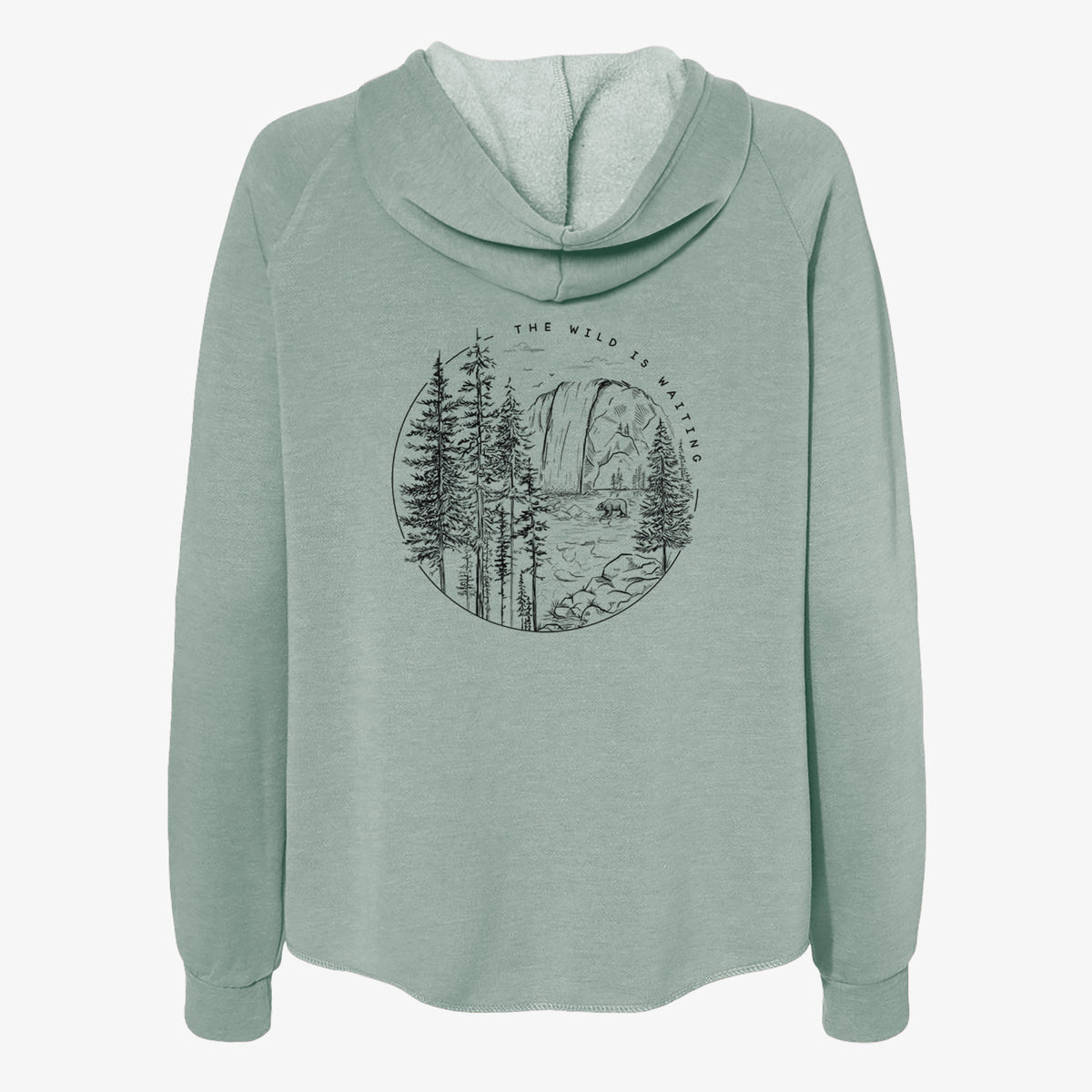 Sage green women's Cali Wave zip-up sweatshirt laid flat, printed with a round black ink scene of a waterfall, pine trees and a river, with the words The Wild Is Waiting.