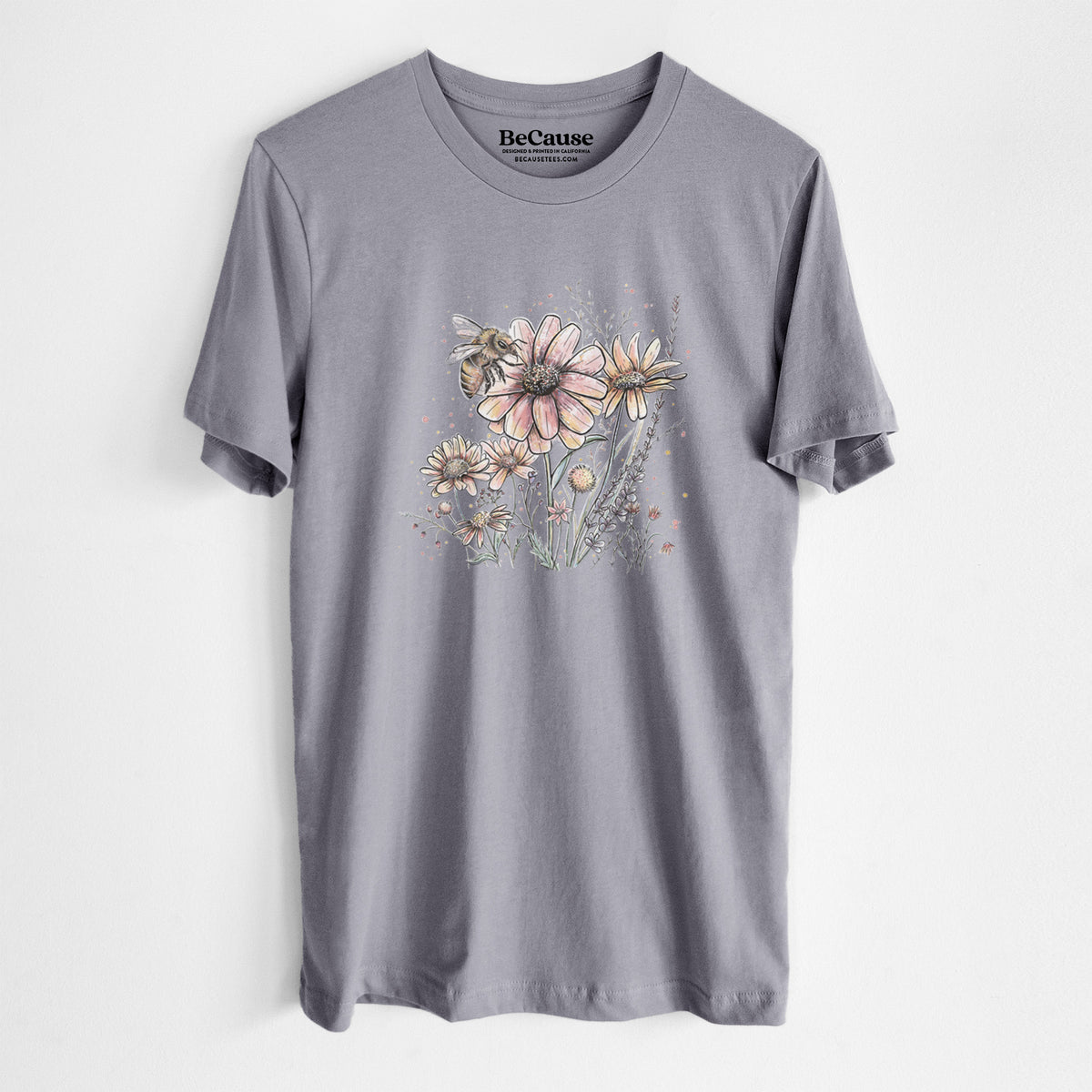 Storm grey lightweight cotton t-shirt laid flat, printed with a soft full-color illustration of a bee flying over pink and purple wildflowers.