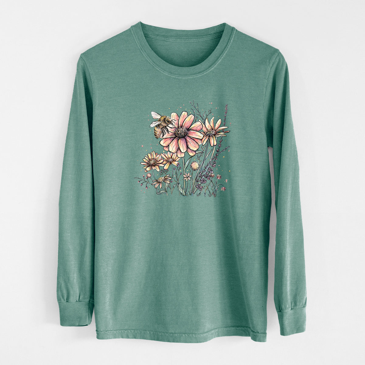 Pine green Comfort Colors long sleeve shirt laid flat, printed with a soft full-color illustration of a bee flying over pink and purple wildflowers.