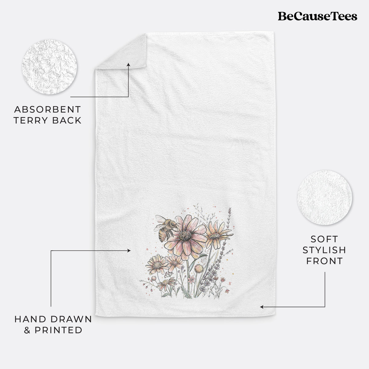 White hand towel printed with a soft full-color illustration of a bee flying over pink and purple wildflowers.