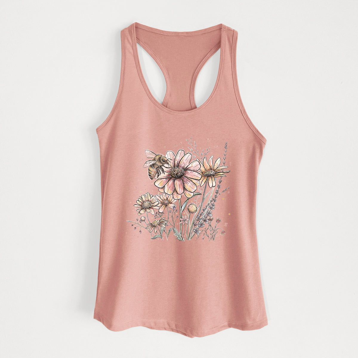 Desert pink women's racerback tank top laid flat, printed with a soft full-color illustration of a bee flying over pink and purple wildflowers.