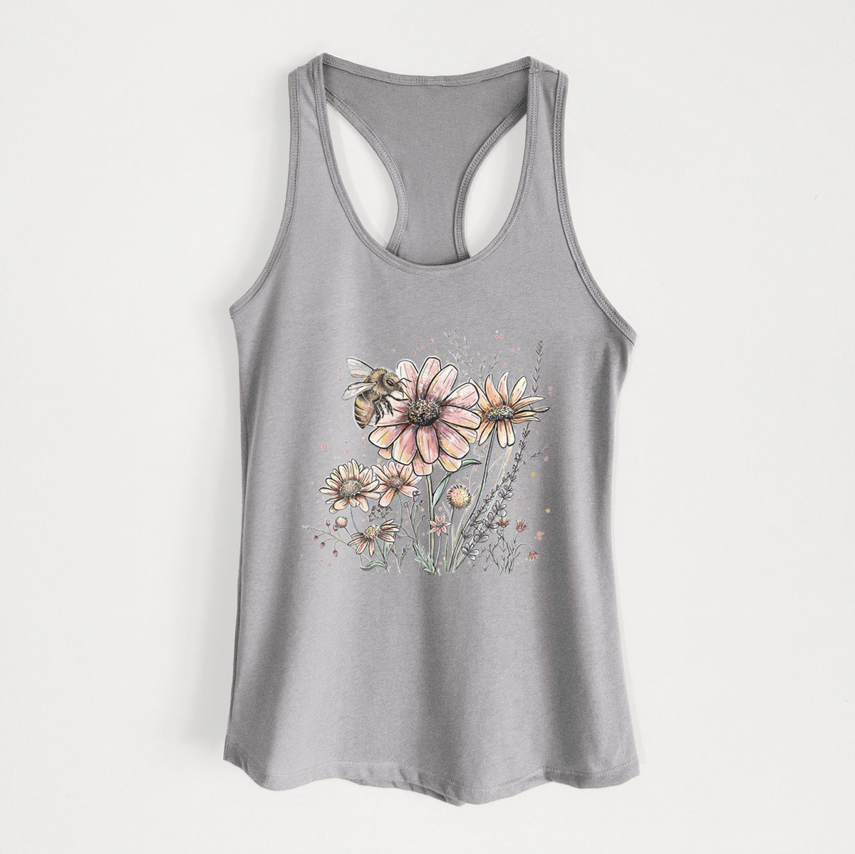Heather grey women's racerback tank top laid flat, printed with a soft full-color illustration of a bee flying over pink and purple wildflowers.