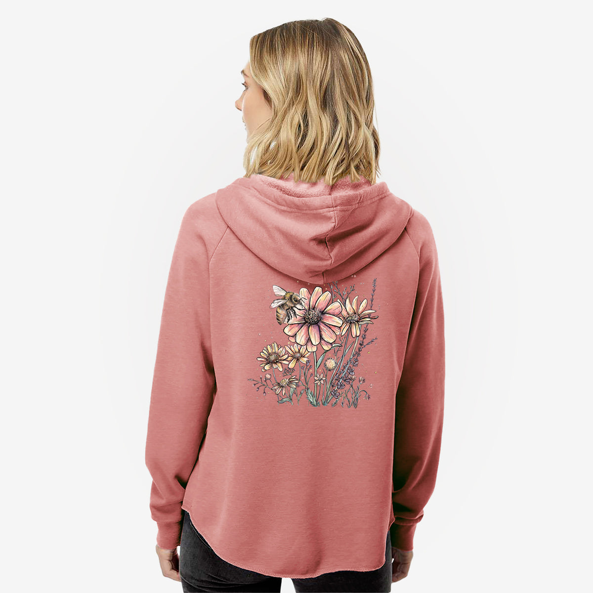 Woman wearing a dusty rose women's Cali Wave zip-up sweatshirt printed with a soft full-color illustration of a bee flying over pink and purple wildflowers, seen from behind.