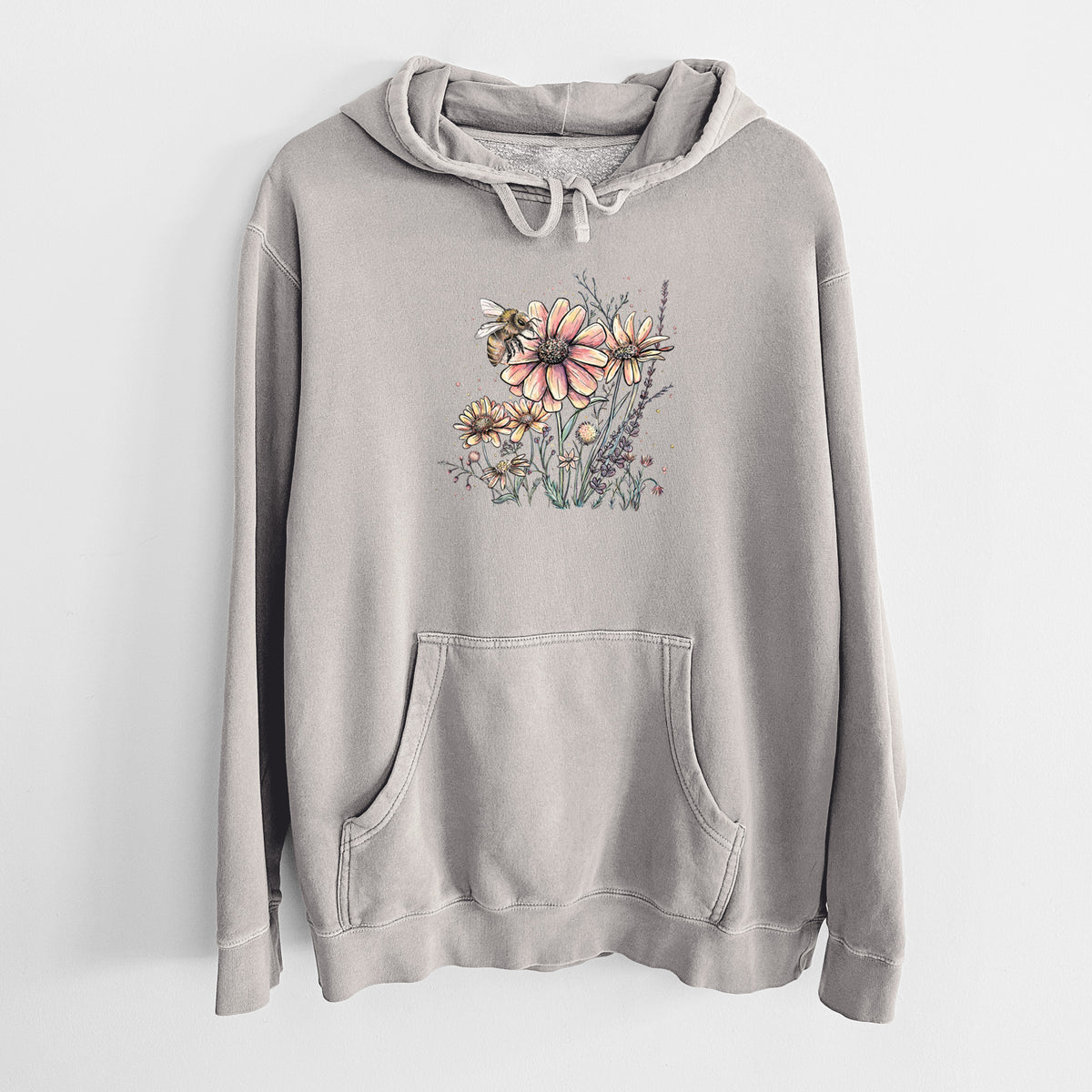 Cement grey pigment dyed hoodie laid flat, printed with a soft full-color illustration of a bee flying over pink and purple wildflowers.