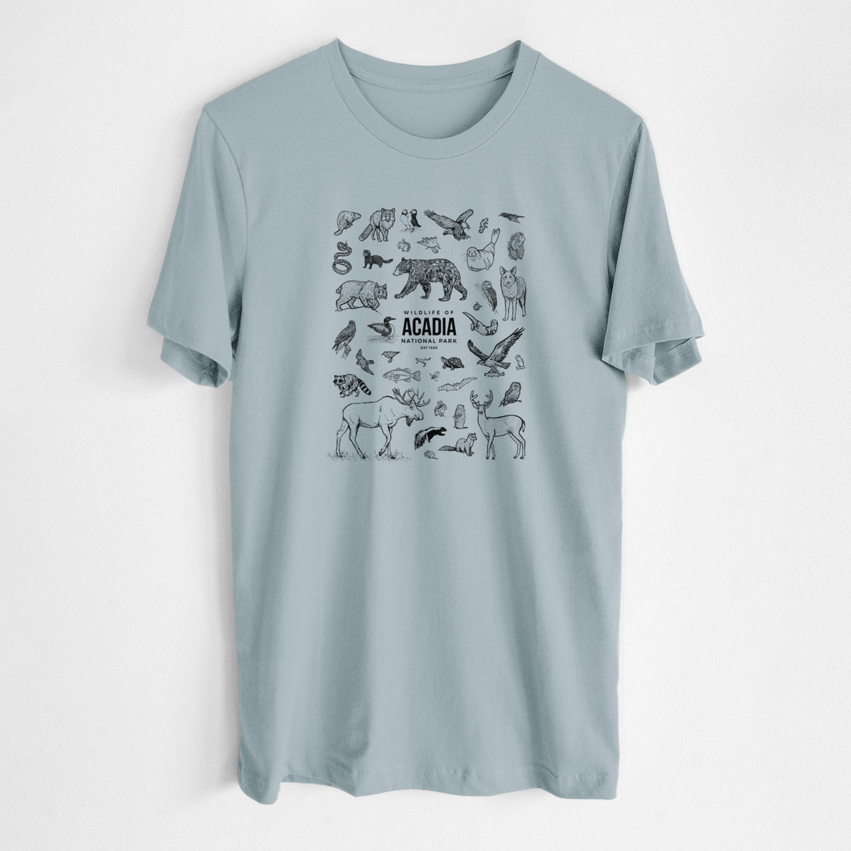 Vintage denim lightweight cotton t-shirt laid flat, printed with a collection of black ink wildlife illustrations surrounding the words Acadia National Park.