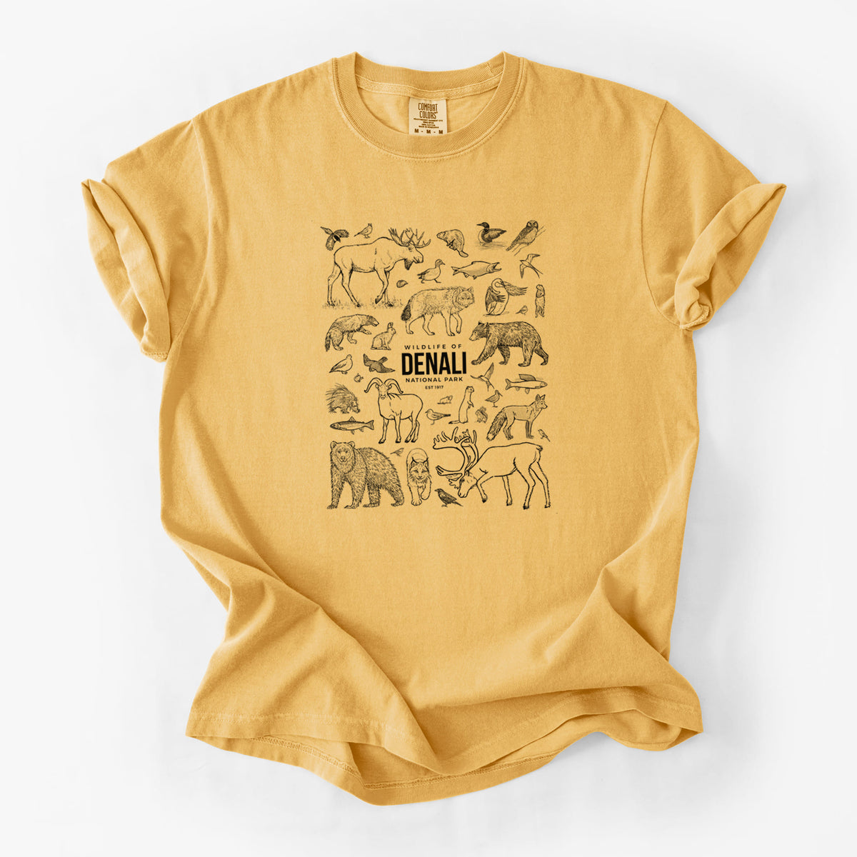 Golden wheat yellow Comfort Colors t-shirt laid flat, printed with a collection of black ink wildlife illustrations surrounding the words Denali National Park.