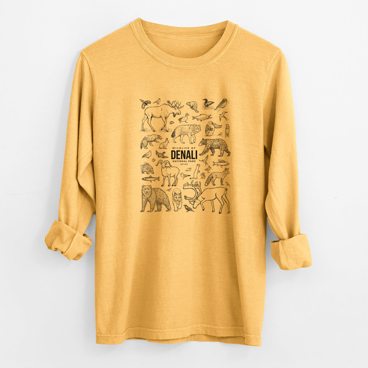 Golden wheat yellow Comfort Colors long sleeve shirt laid flat with the cuffs rolled, printed with a collection of black ink wildlife illustrations surrounding the words Denali National Park.