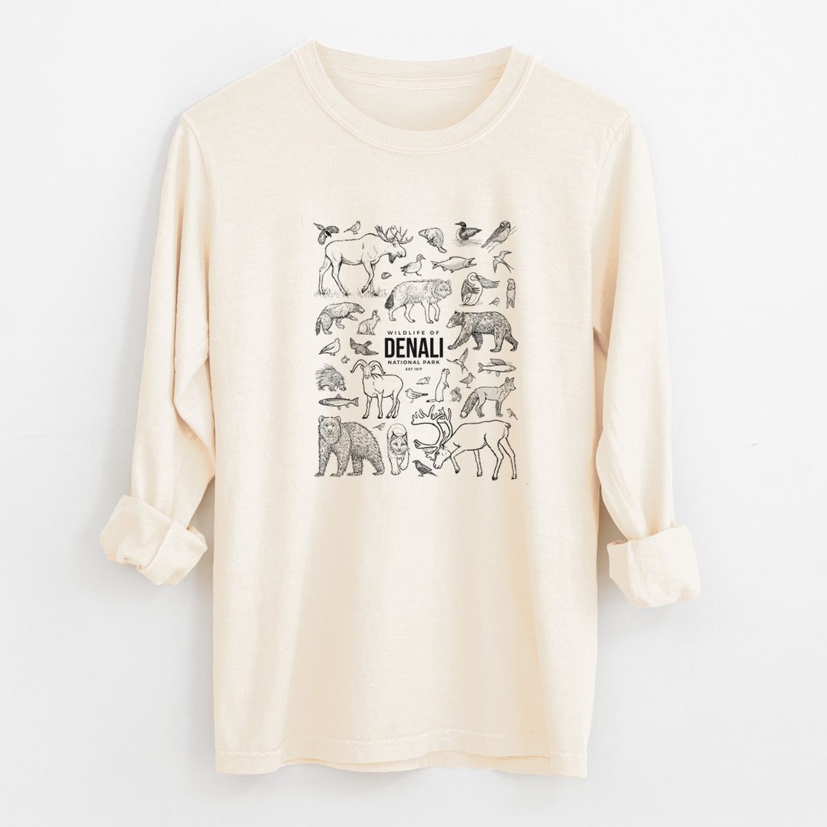 Ivory Comfort Colors long sleeve shirt laid flat with the cuffs rolled, printed with a collection of black ink wildlife illustrations surrounding the words Denali National Park.