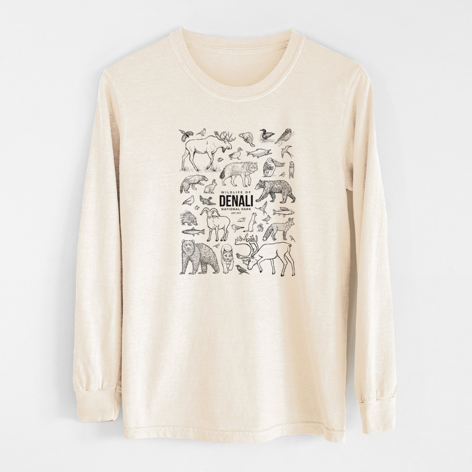 Ivory Comfort Colors long sleeve shirt laid flat, printed with a collection of black ink wildlife illustrations surrounding the words Denali National Park.