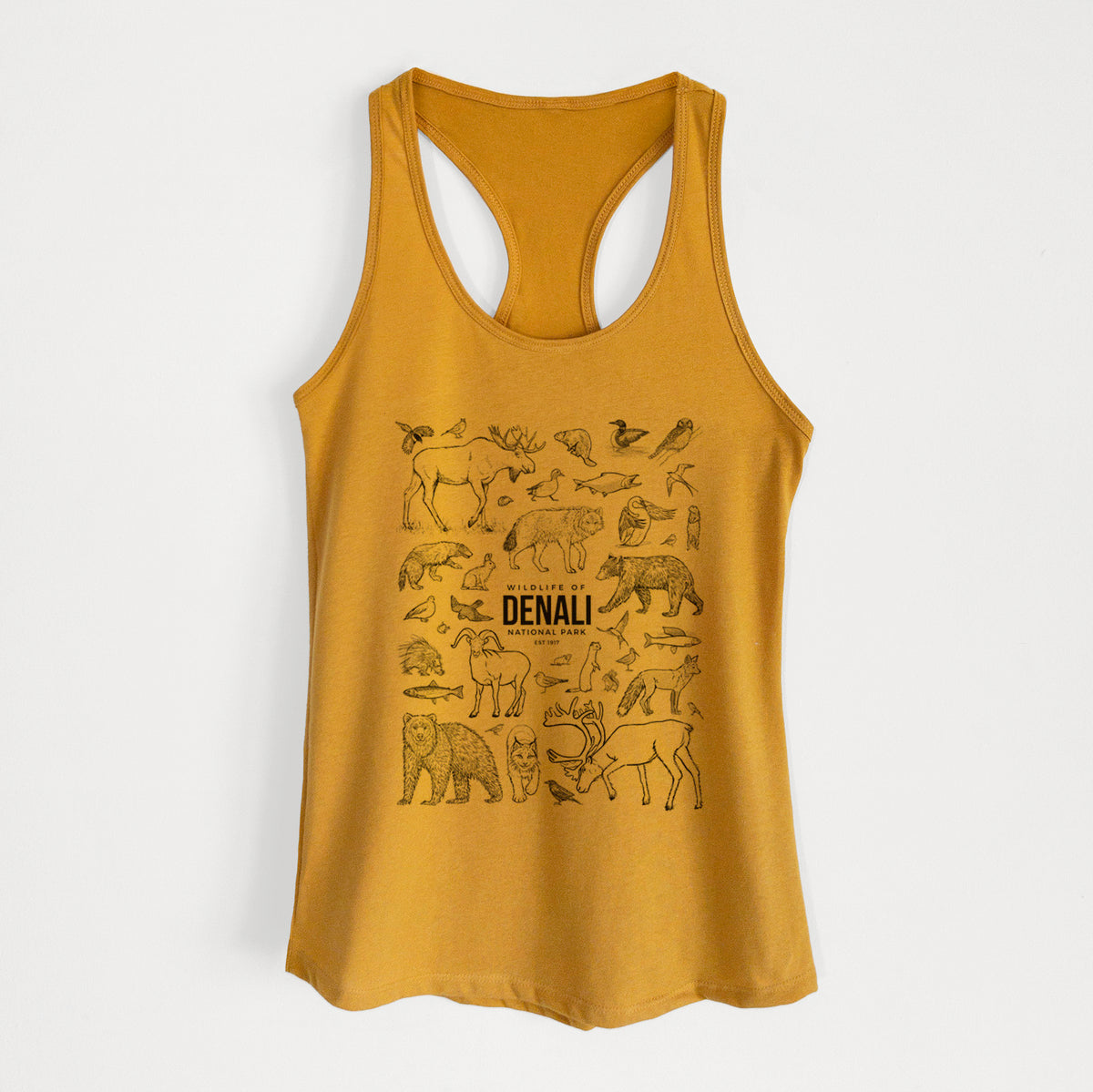 Gold women's racerback tank top laid flat, printed with a collection of black ink wildlife illustrations surrounding the words Denali National Park.