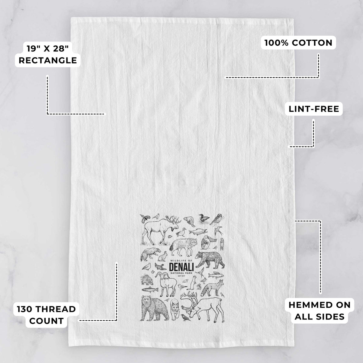 White tea towel printed with a collection of black ink wildlife illustrations surrounding the words Denali National Park, with feature labels: 19 by 28 inch rectangle, 100% cotton, lint-free, 130 thread count, hemmed on all sides.