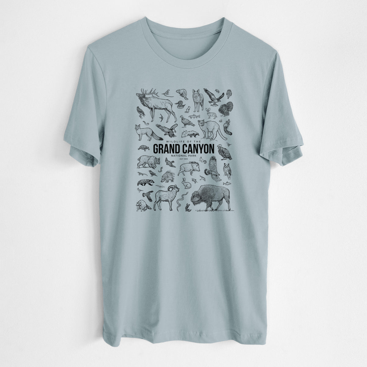 Vintage denim lightweight cotton t-shirt laid flat, printed with a collection of black ink wildlife illustrations surrounding the words Grand Canyon National Park.