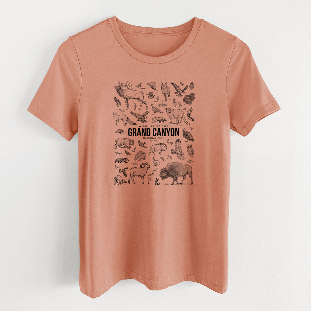 Terracotta orange women's relaxed fit cotton t-shirt laid flat, printed with a collection of black ink wildlife illustrations surrounding the words Grand Canyon National Park.