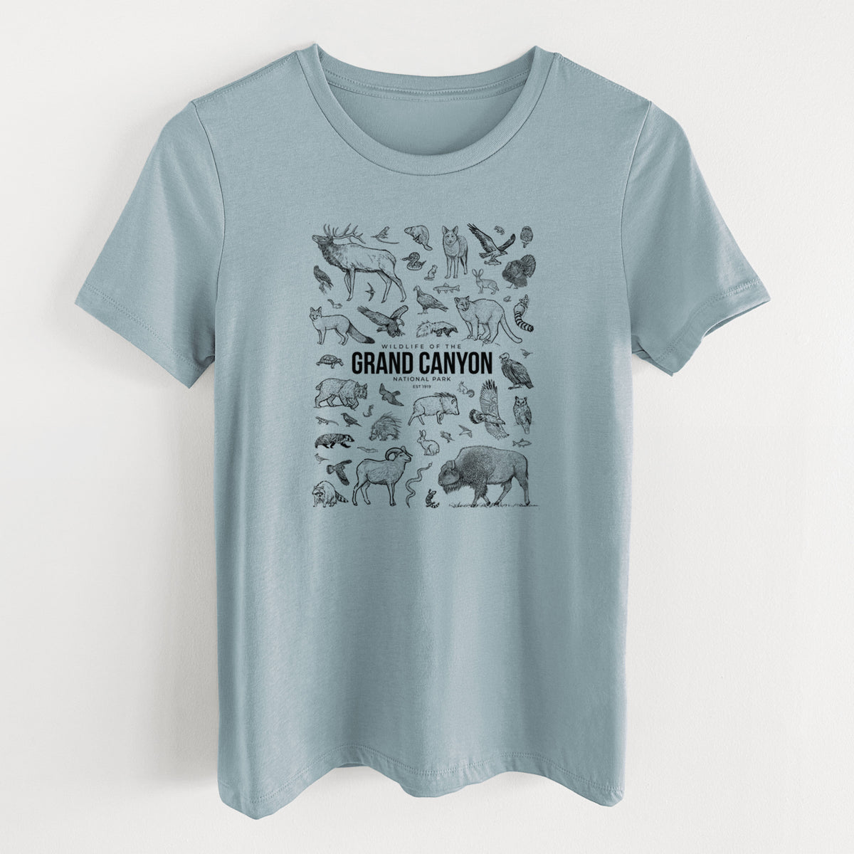 Vintage denim women's relaxed fit cotton t-shirt laid flat, printed with a collection of black ink wildlife illustrations surrounding the words Grand Canyon National Park.