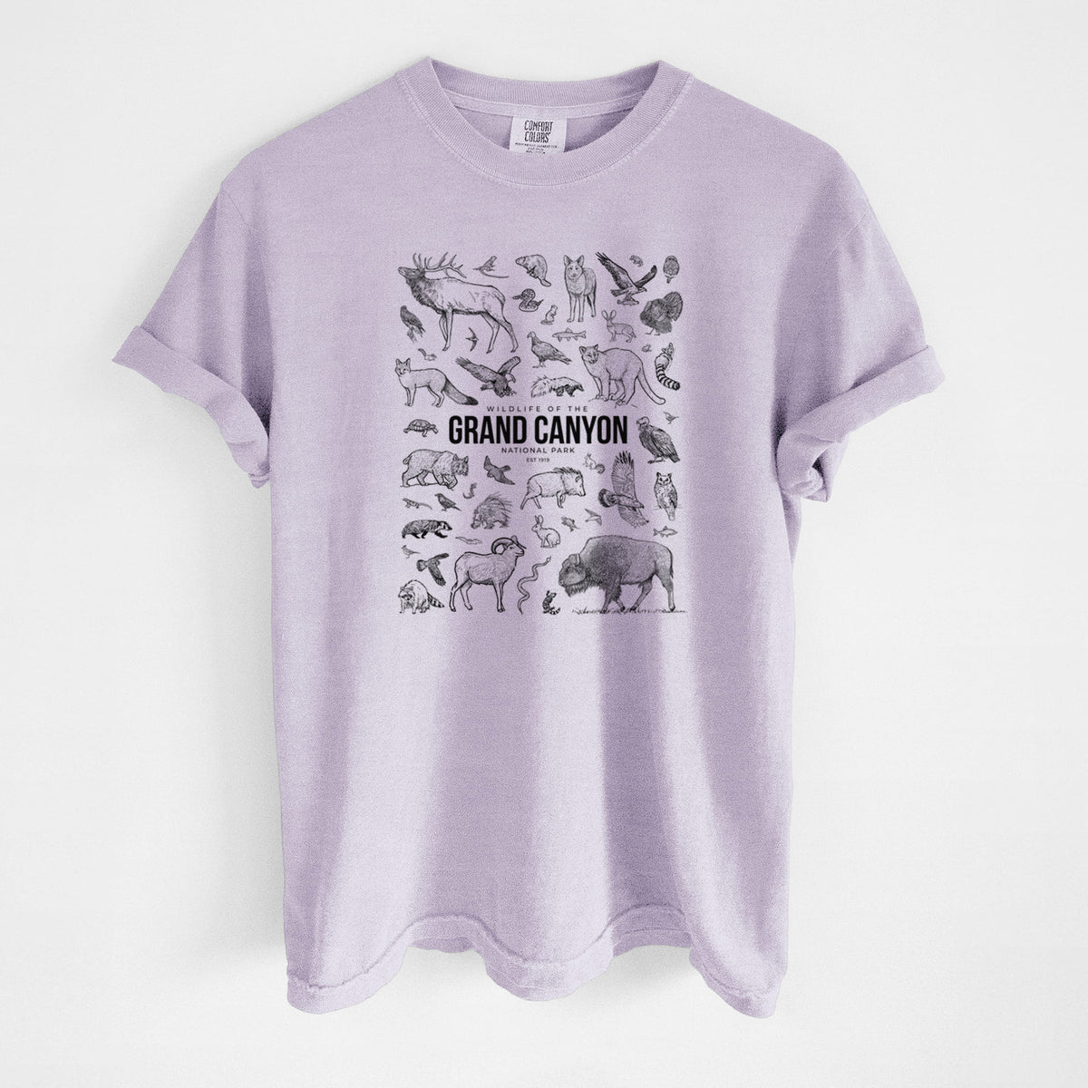 Orchid purple Comfort Colors t-shirt laid flat, printed with a collection of black ink wildlife illustrations surrounding the words Grand Canyon National Park.
