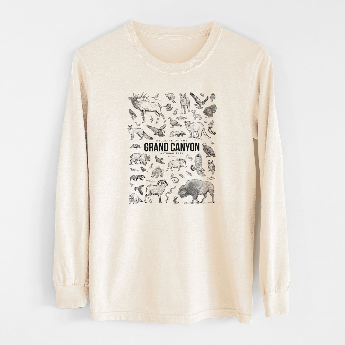 Ivory Comfort Colors long sleeve shirt laid flat, printed with a collection of black ink wildlife illustrations surrounding the words Grand Canyon National Park.