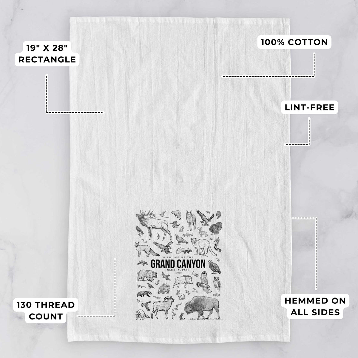 White tea towel printed with a collection of black ink wildlife illustrations surrounding the words Grand Canyon National Park, with feature labels: 19 by 28 inch rectangle, 100% cotton, lint-free, 130 thread count, hemmed on all sides.