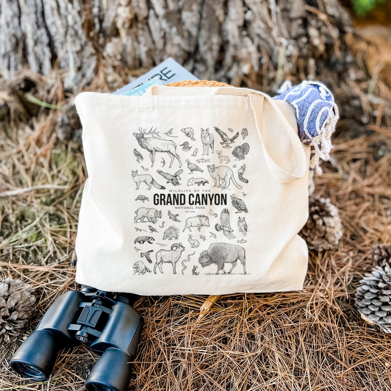Natural canvas tote bag printed with a collection of black ink wildlife illustrations surrounding the words Grand Canyon National Park.