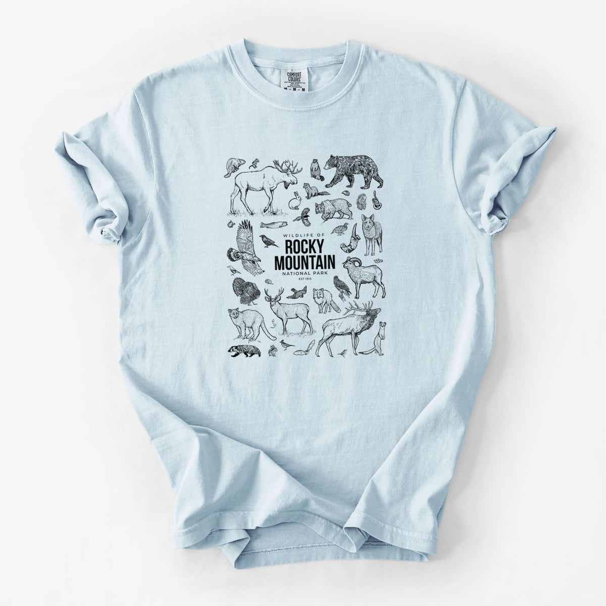 Chambray blue Comfort Colors t-shirt laid flat, printed with a collection of black ink wildlife illustrations surrounding the words Rocky Mountain National Park.