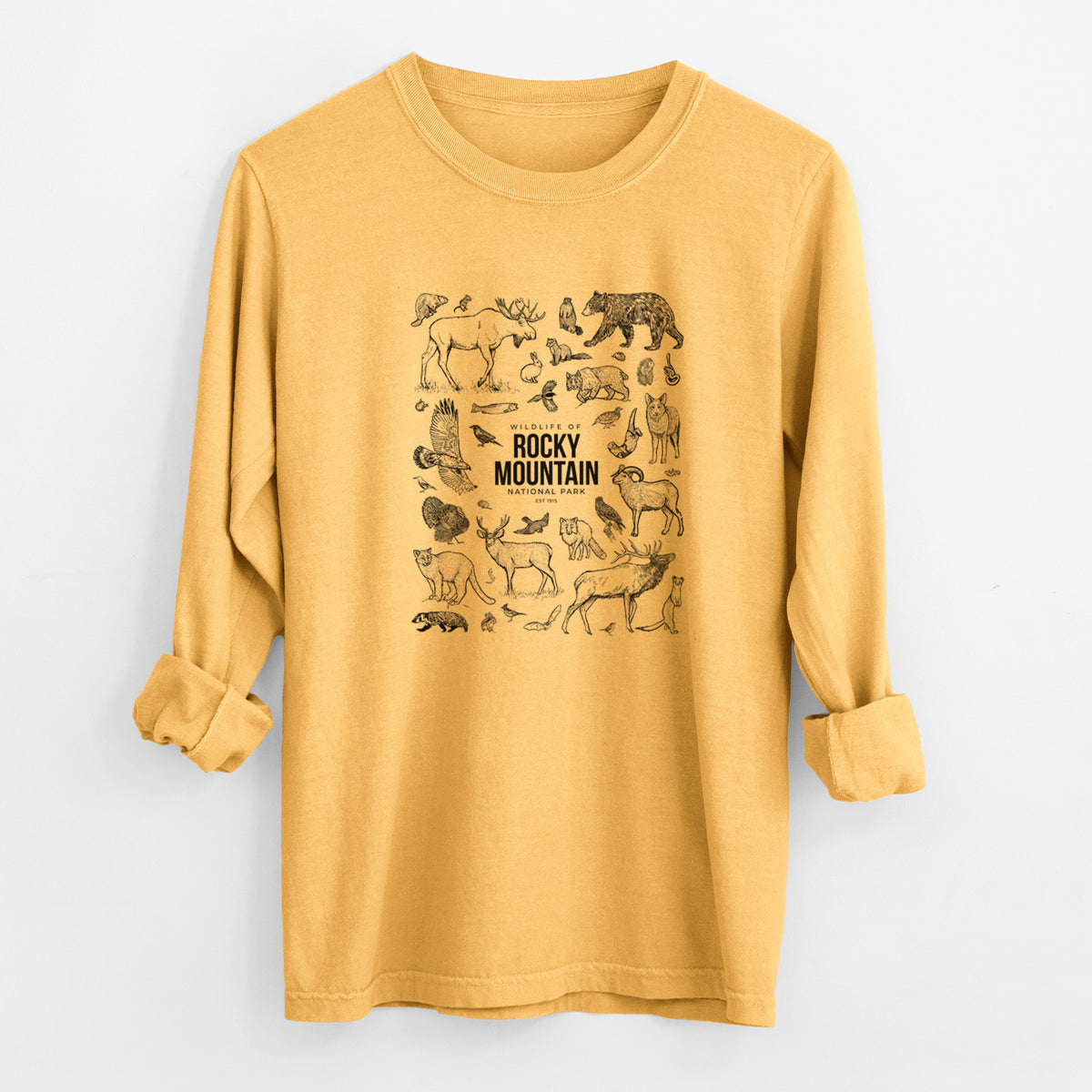 Golden wheat yellow Comfort Colors long sleeve shirt laid flat with the cuffs rolled, printed with a collection of black ink wildlife illustrations surrounding the words Rocky Mountain National Park.