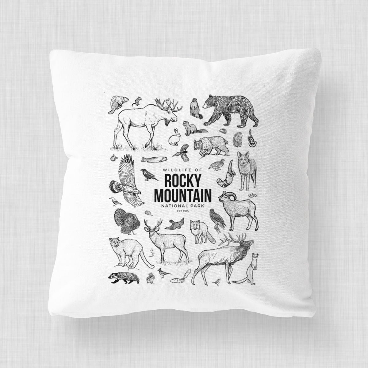 White pillow cover printed with a collection of black ink wildlife illustrations surrounding the words Rocky Mountain National Park.