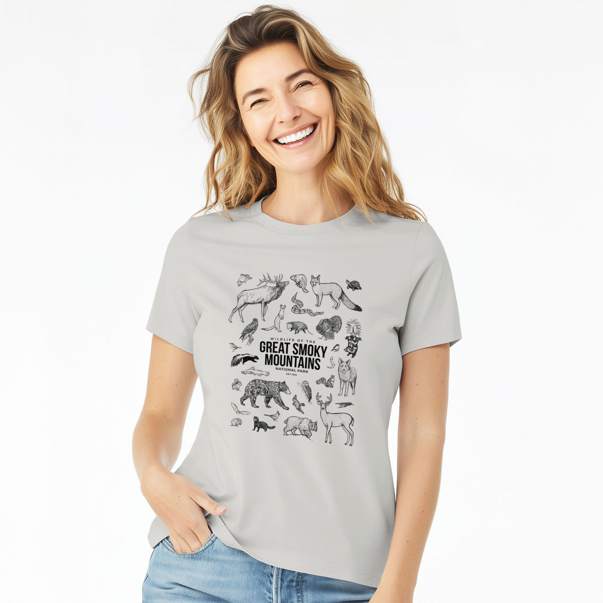 Woman wearing a lunar grey women's relaxed fit cotton t-shirt printed with a collection of black ink wildlife illustrations surrounding the words Great Smoky Mountains National Park.
