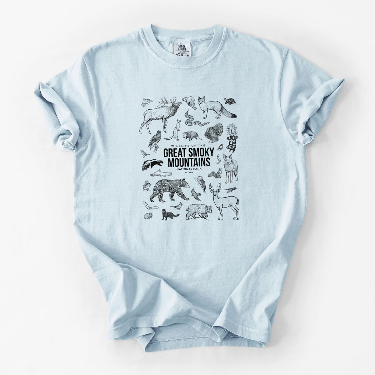 Chambray blue Comfort Colors t-shirt laid flat, printed with a collection of black ink wildlife illustrations surrounding the words Great Smoky Mountains National Park.
