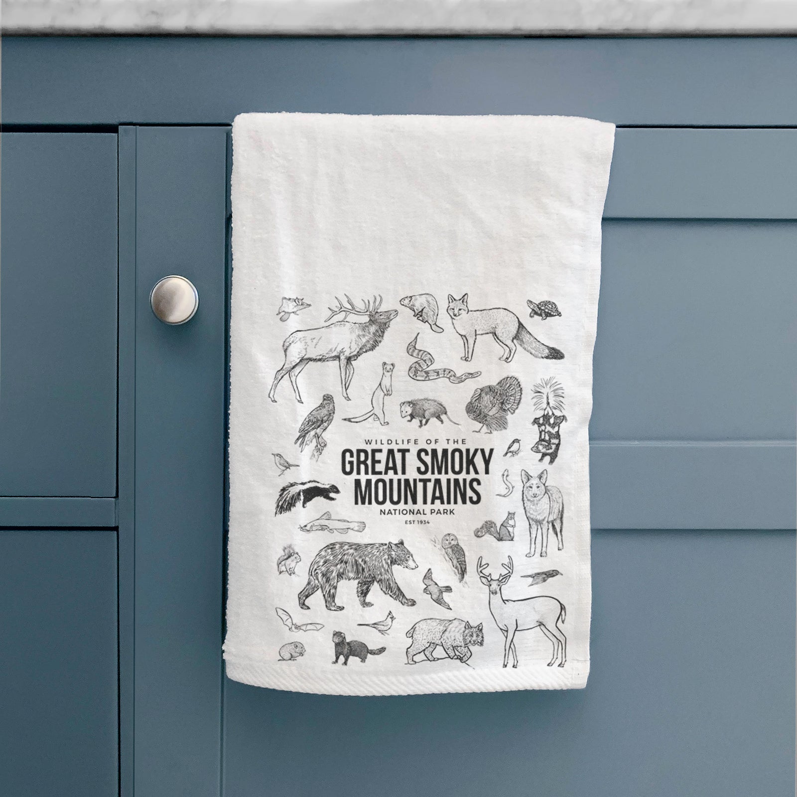 White hand towel printed with a collection of black ink wildlife illustrations surrounding the words Great Smoky Mountains National Park.