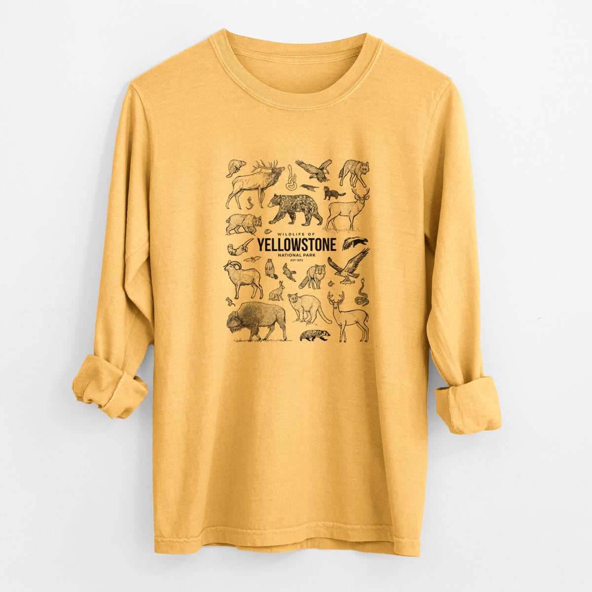 Golden wheat yellow Comfort Colors long sleeve shirt laid flat with the cuffs rolled, printed with a collection of black ink wildlife illustrations surrounding the words Yellowstone National Park.